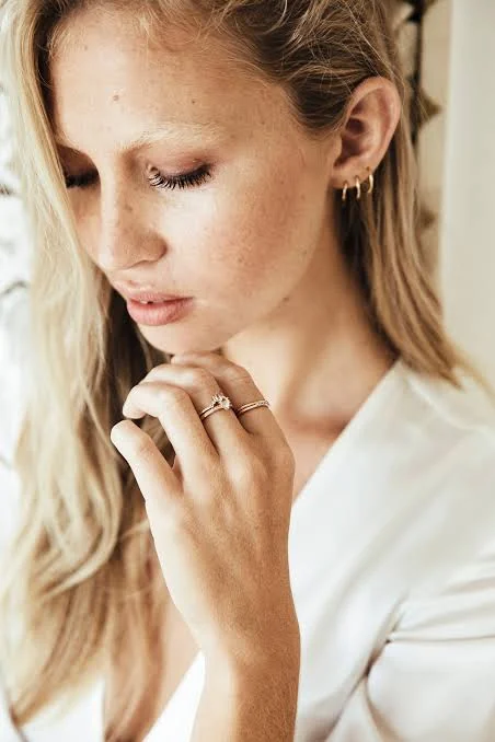 Model wearing a YCL Jewels ring and gold earrings